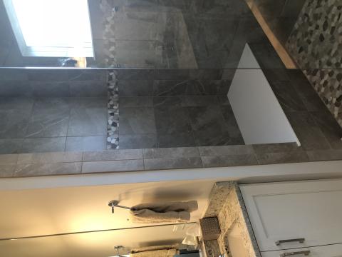 Walk in shower with stone pebble floor and band detail