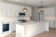 The custom Oakfied Ranch home kitchen with Cafe appliances and white cabinets